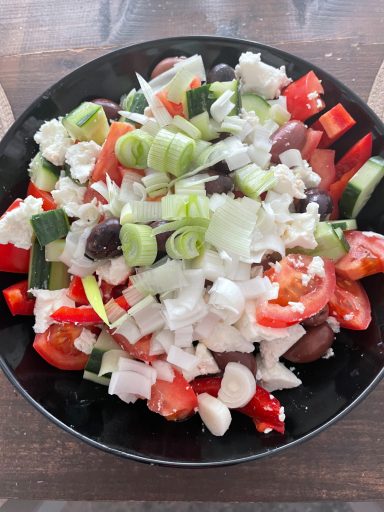 Färsk sallad med tomater, gurka, oliver, fetaost och purjolök.